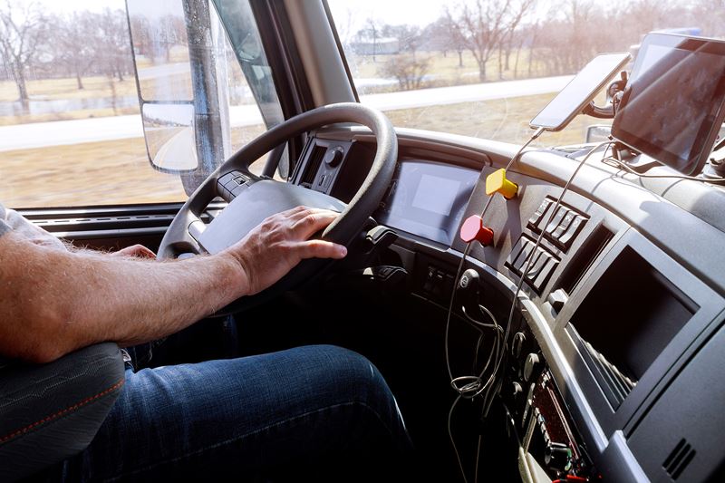 Conducteur dans la cabine d'un gros camion moderne sur l'autoroute